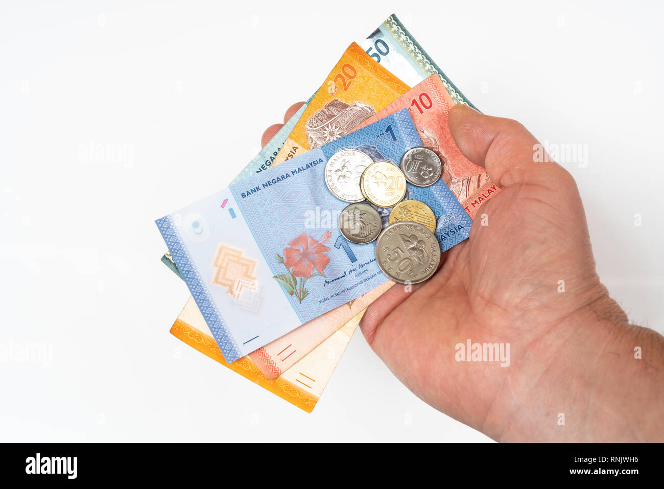 Alcuni ringgit malese di banconote e monete in mano Foto Stock