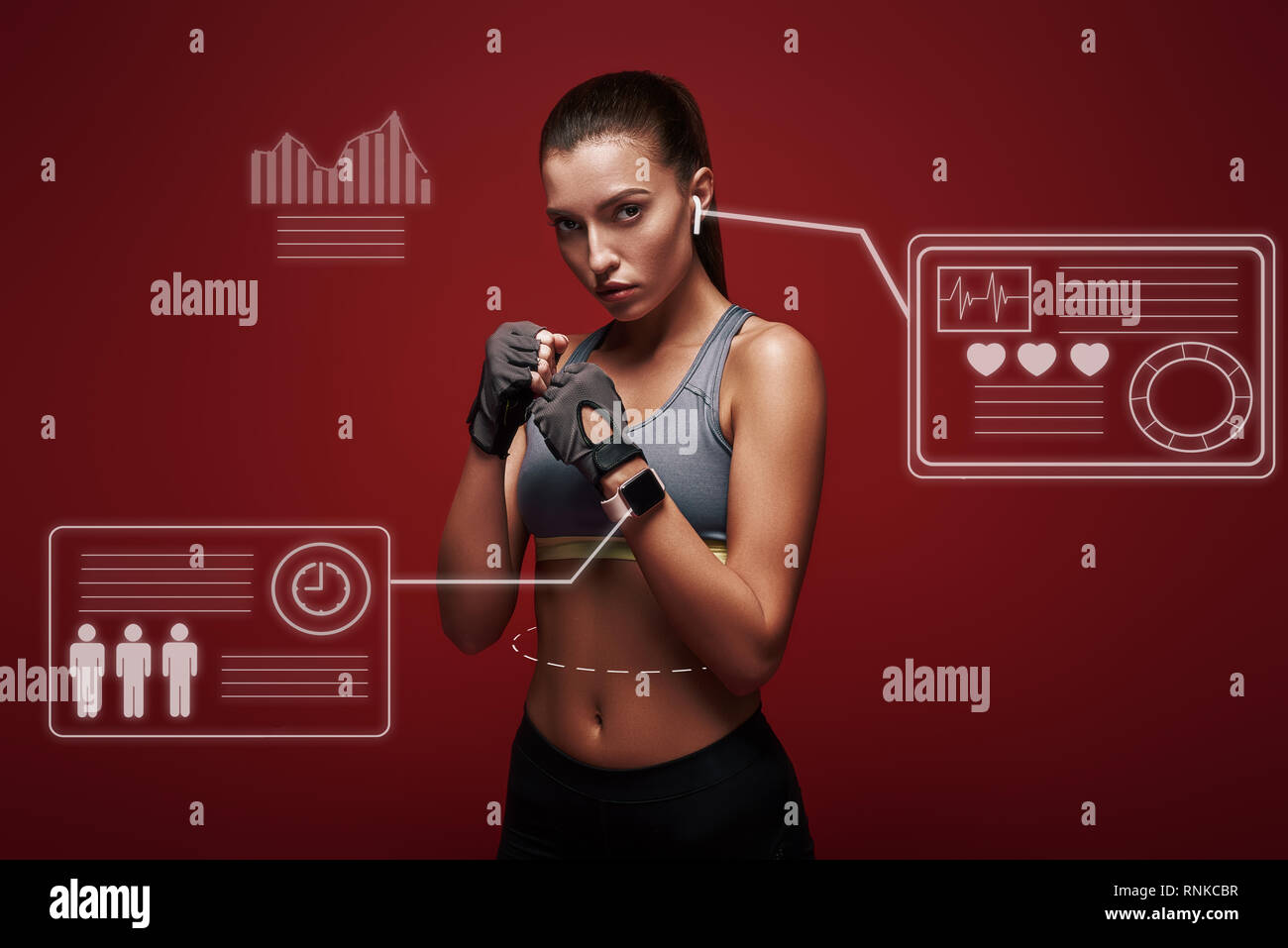 Bella sportive indossando guanti di allenamento è pronto per l'esercizio. Isolato su sfondo rosso Foto Stock