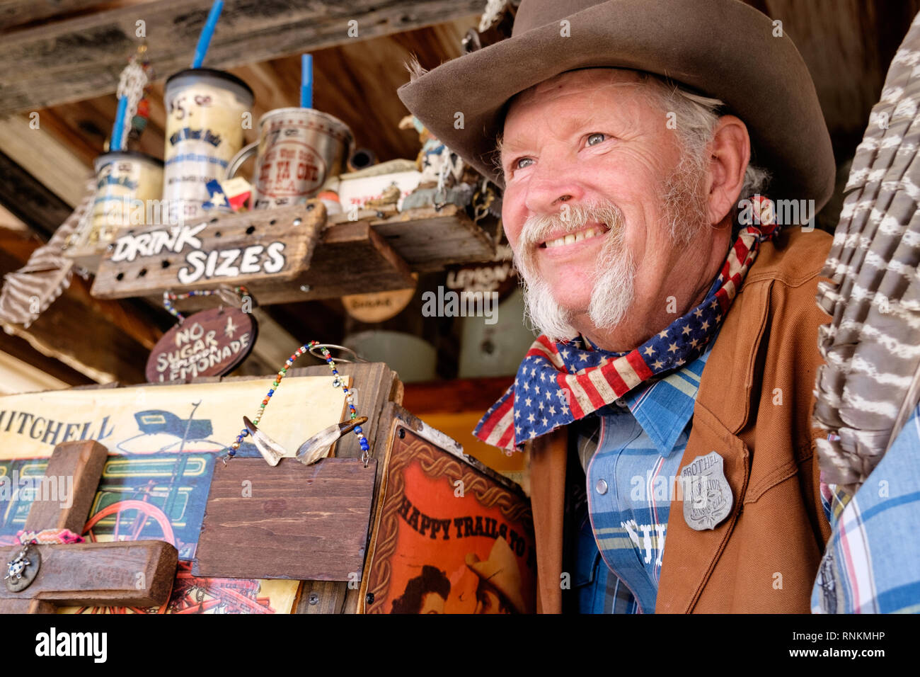 Staycation. Sorridente cowboy texano con cappello cowboy, sciarpa e baffi  bianchi a ferro di cavallo al mercato Wild West Soda. Trade Days Market  Foto stock - Alamy