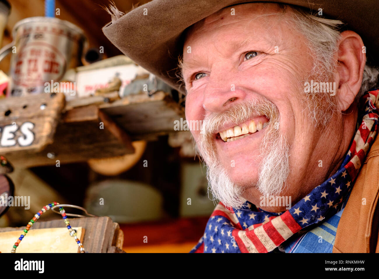 Staycation. Sorridente cowboy texano con cappello cowboy, sciarpa e baffi  bianchi a ferro di cavallo al mercato Wild West Soda. Trade Days Market  Foto stock - Alamy