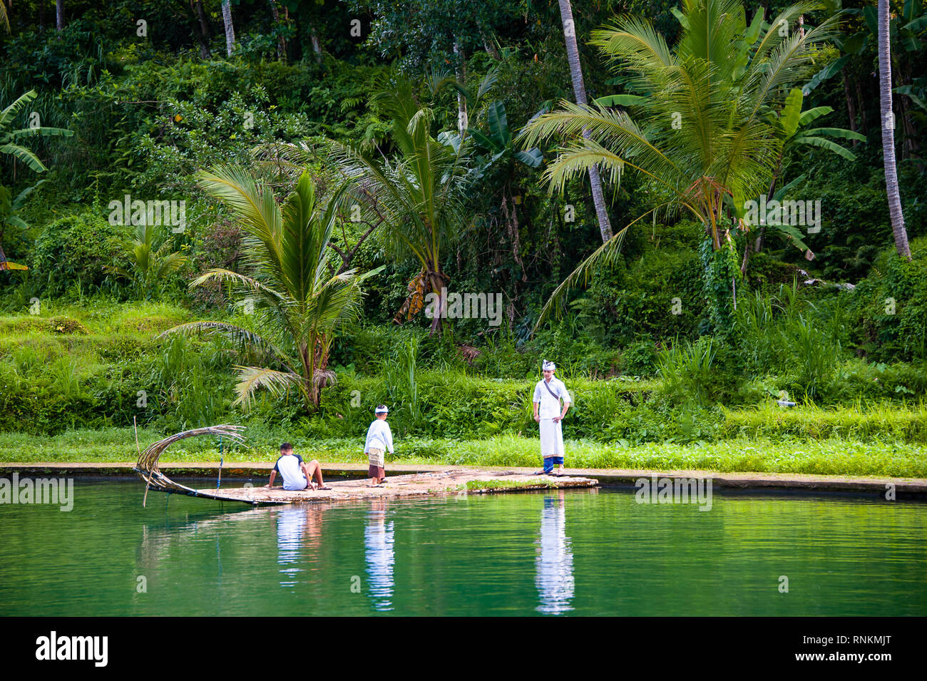 In stile Balinese in abito tradizionale visita Tirta Taman Mumbal tempio dell'acqua e il lago per celebrare una festa religiosa. Foto Stock