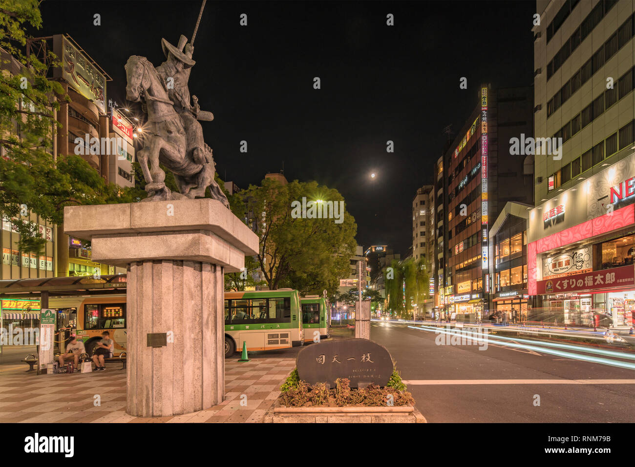 Vista notturna della piazza di fronte alla Nippori stazione ferroviaria nel quartiere Arakawa di Tokyo con una statua di un cavallo cavalcato da Ota Dokan che era un Foto Stock