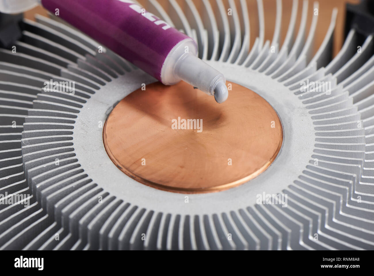 Applicare la pasta termica sulla superficie del dissipatore di calore Foto Stock