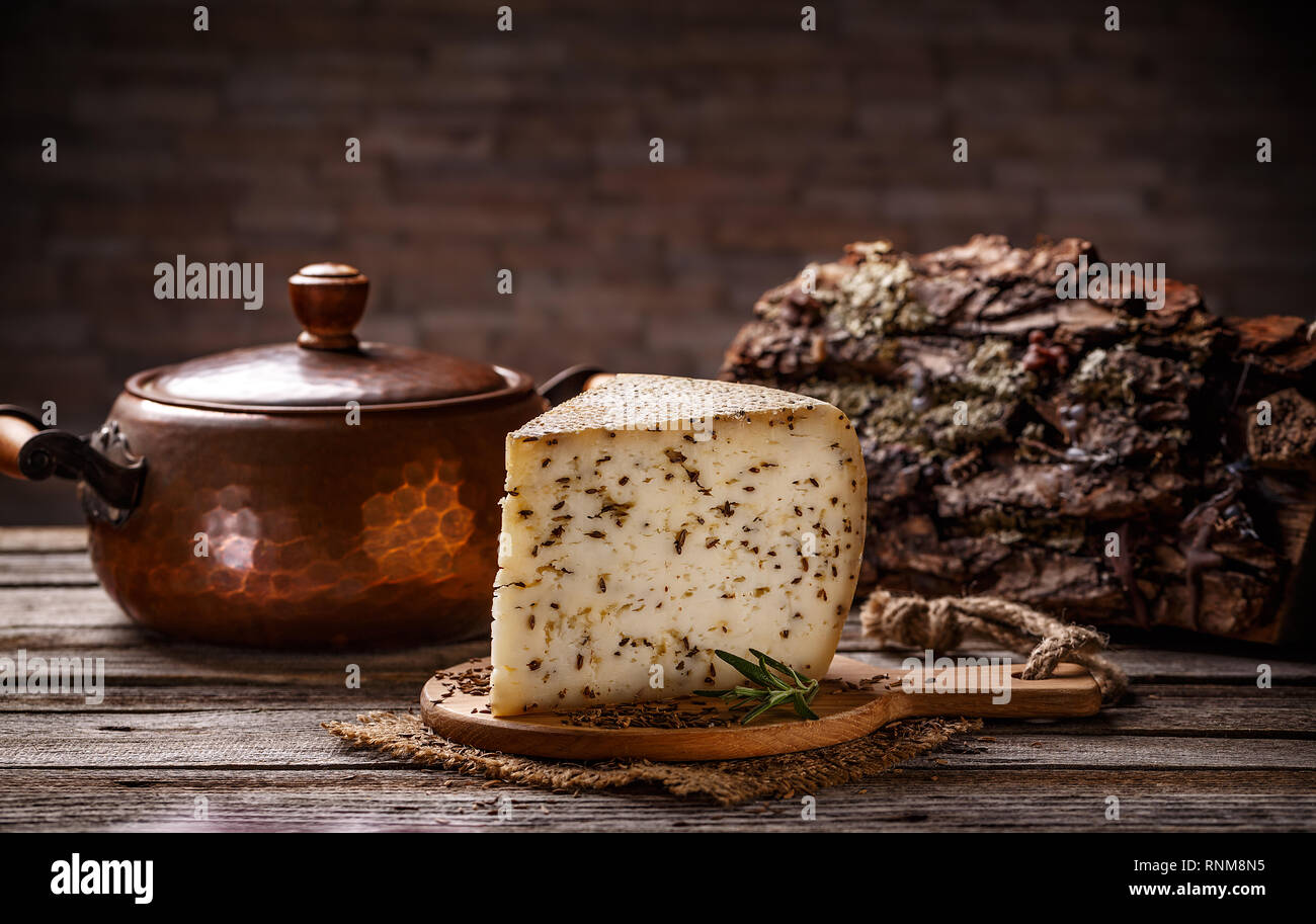 Fetta di formaggio con cummin su vintage sfondo di legno Foto Stock