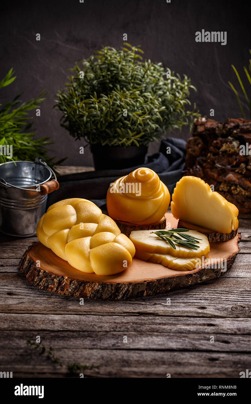 Composizione con affumicato formaggio intrecciato su sfondo di legno Foto Stock
