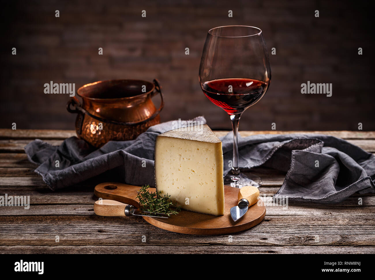 Pezzo di formaggio con un bicchiere di vino rosso sul vintage sfondo di legno Foto Stock