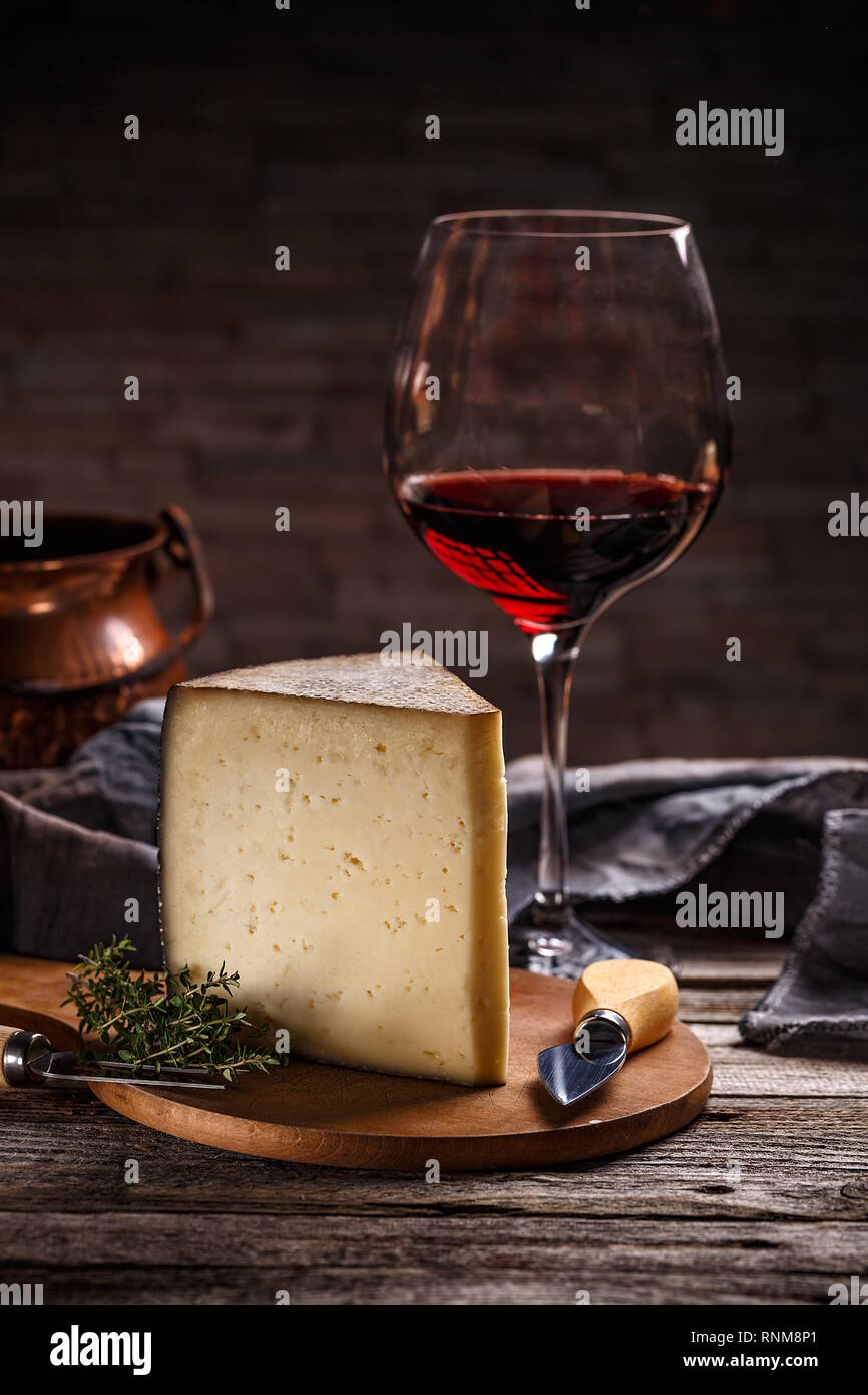 Bicchiere di vino rosso e formaggio ancora vita su sfondo di legno Foto Stock