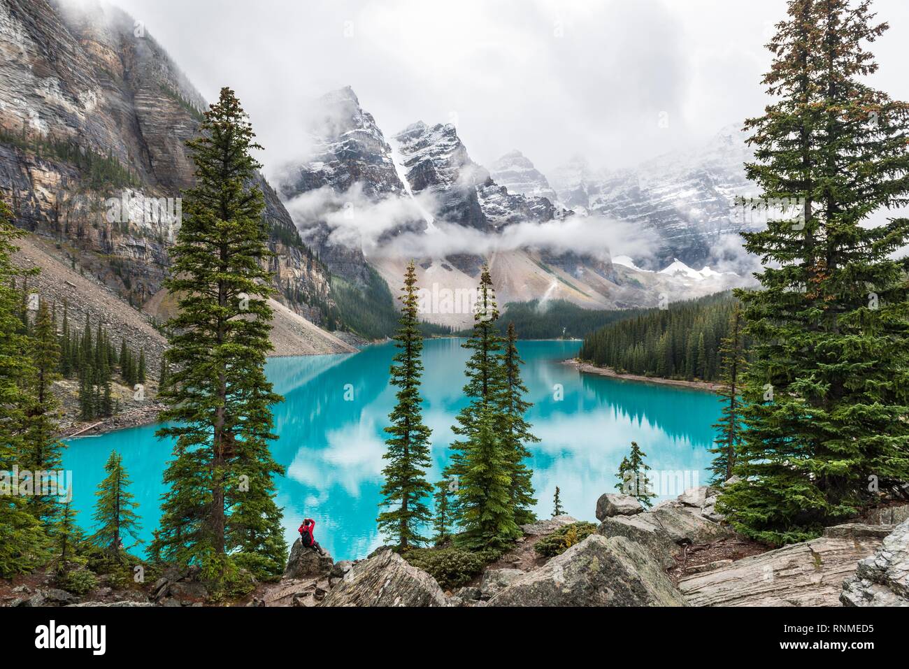 Nuvole e sospesi tra le cime della montagna e la riflessione in turchese lago glaciale, Moraine Lake, Valle dei Dieci Picchi, montagne rocciose, Banff Nationa Foto Stock