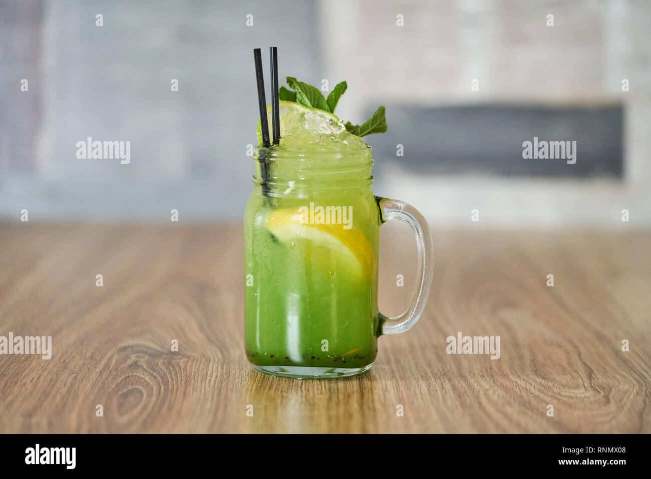 Freddo rinfrescante Kiwi limonata con la menta guarnire a mason jar con sfondo di legno Foto Stock