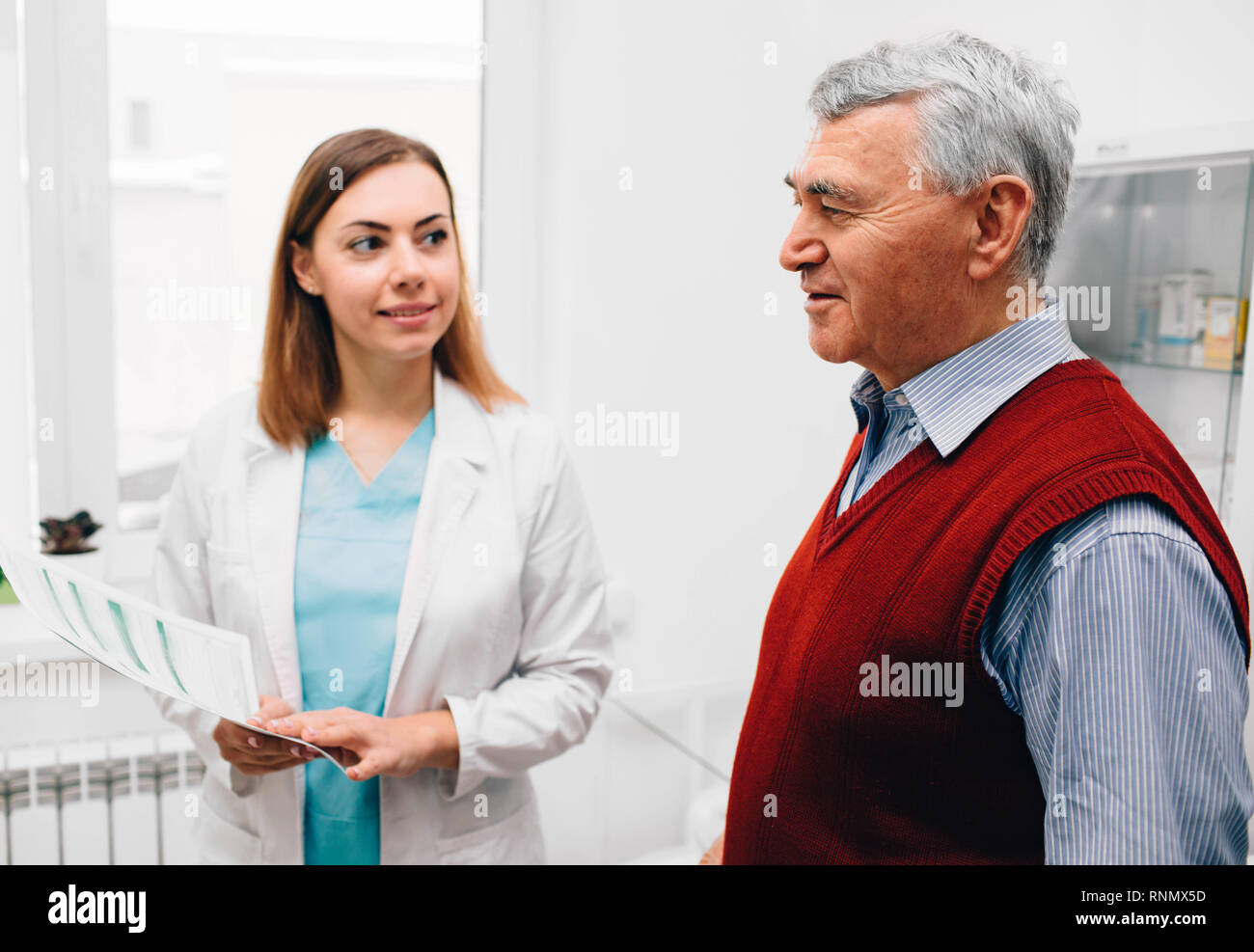Uomo anziano si consulta con il suo medico in clinica Foto Stock
