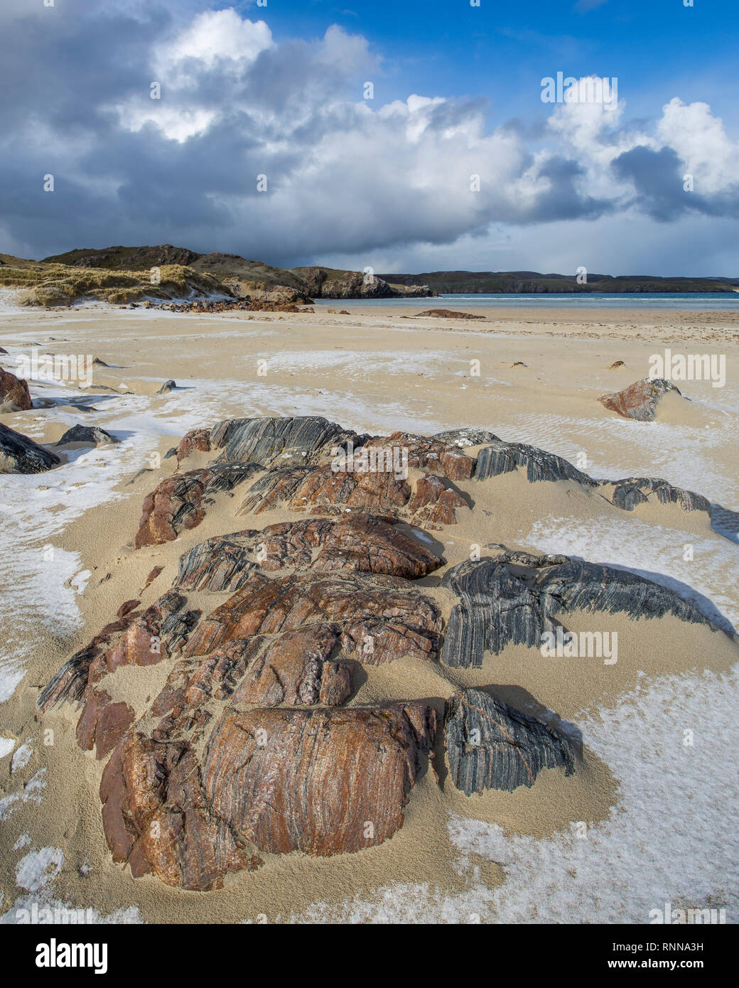 Lewisian Gneiss rock formazione sulla spiaggia di Uige, isola di Lewis, Ebridi Esterne, Scozia. Visto dopo una doccia di grandine. Foto Stock