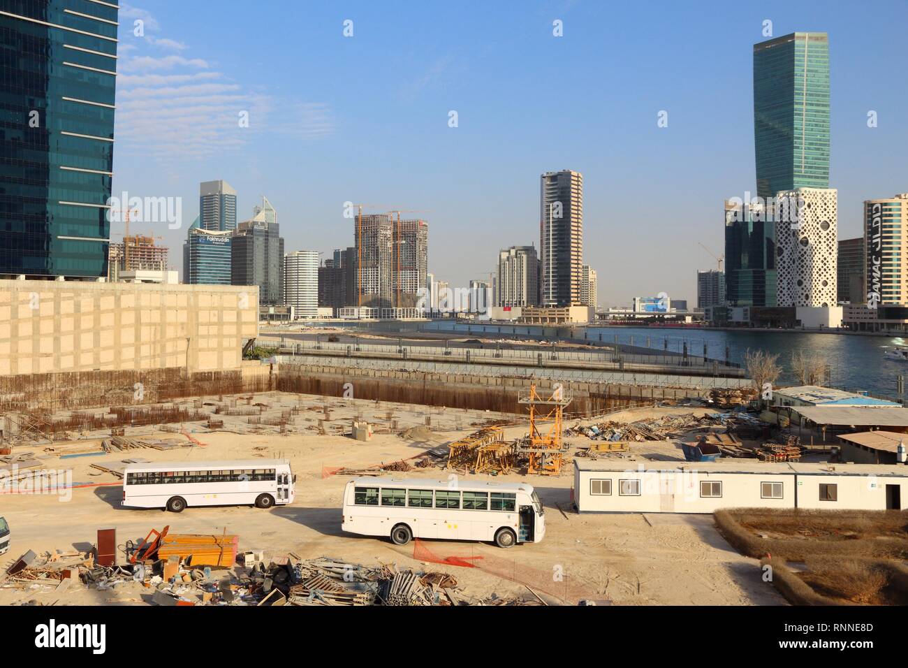 DUBAI, Emirati Arabi Uniti - 22 novembre 2017: il continuo sviluppo del Business Bay in Dubai Emirati Arabi Uniti. Gli autobus bianco portare costruzione migranti lavoratori a Foto Stock