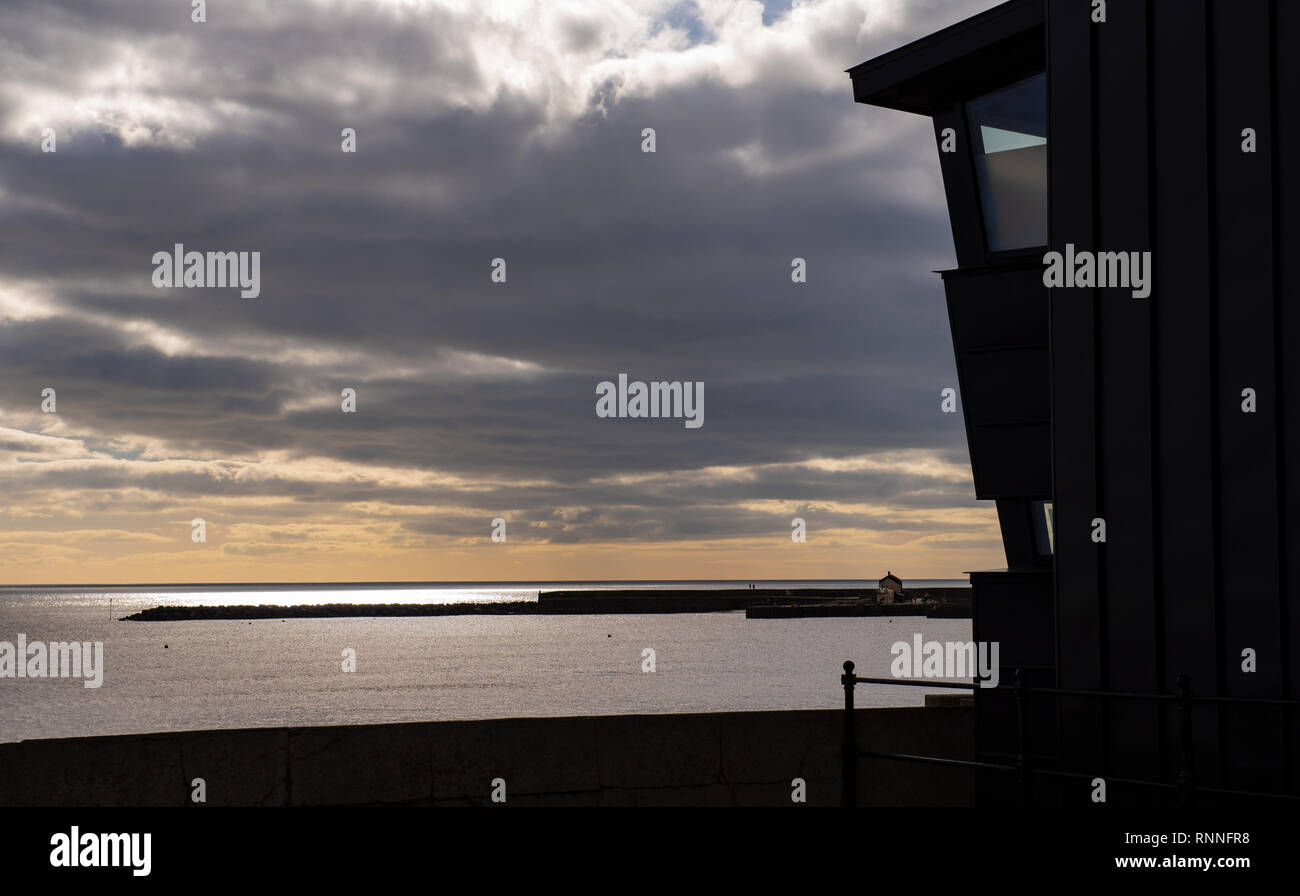 Esterno moderno di Lyme Regis Museum (l'Philpot museo) a Lyme Regis sillhouted contro un cielo invernale con il Cobb nella distanza. Foto Stock