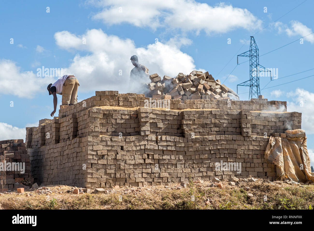 Creatori di mattoni creando un forno, Madagascar Foto Stock