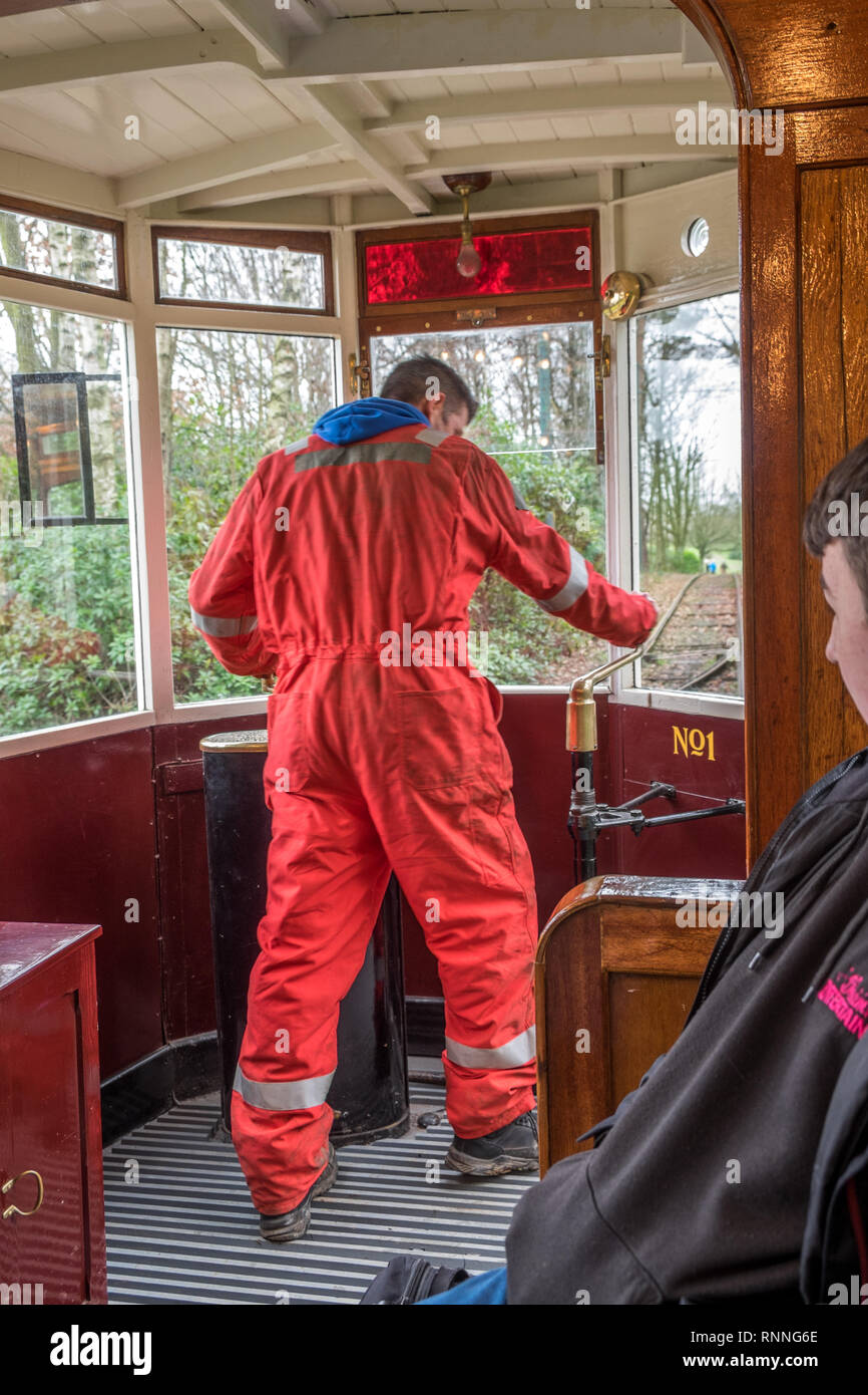 Ingegnere guidando il patrimonio tram utilizzando la leva del freno per il comando di arresto della squadra. Foto Stock