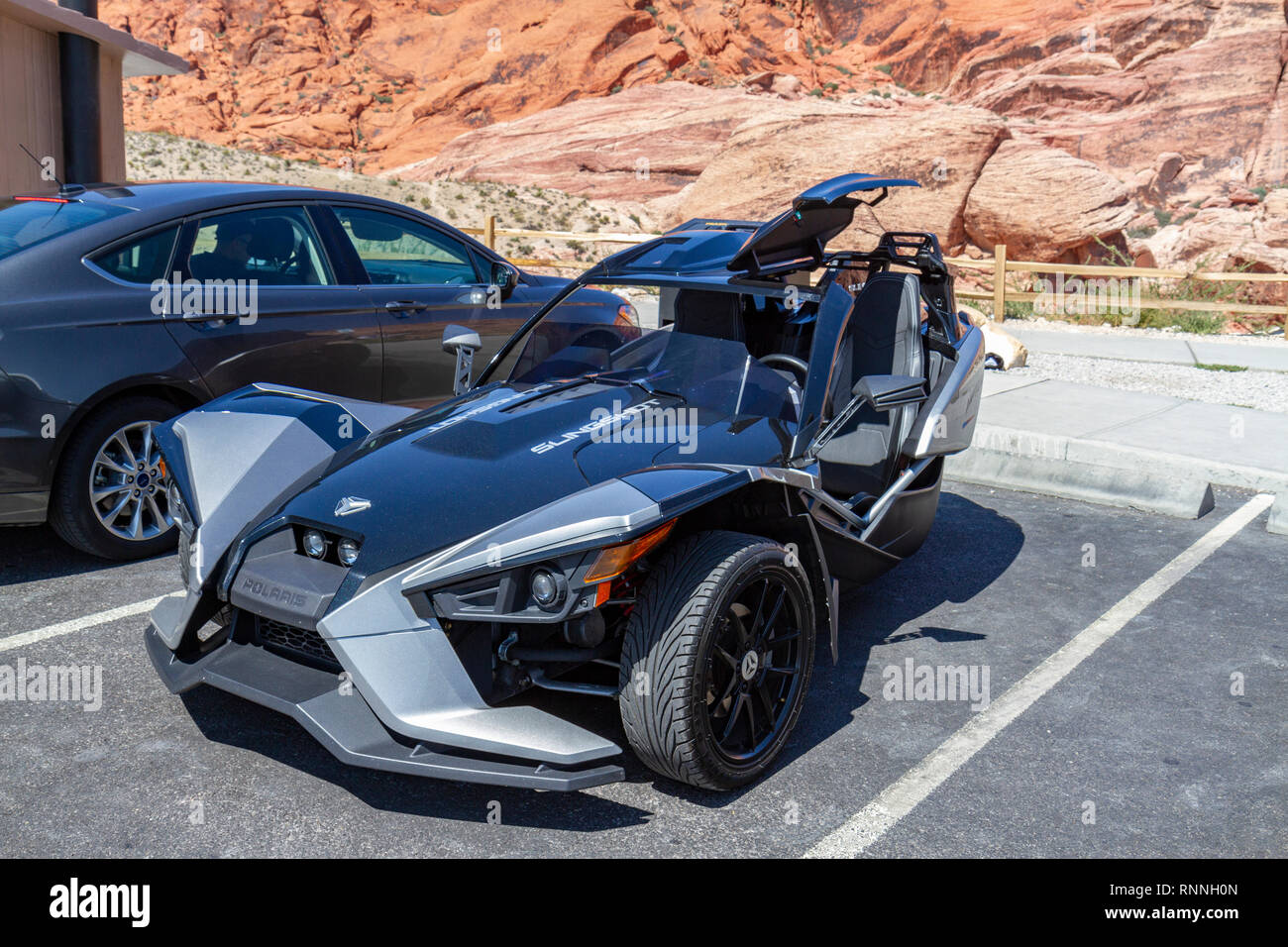 Un Slingshot Polaris open-air roadster 3 moto della ruota (l'auto?), il Red Rock Canyon National Conservation Area, Las Vegas, Nevada, Stati Uniti. Foto Stock