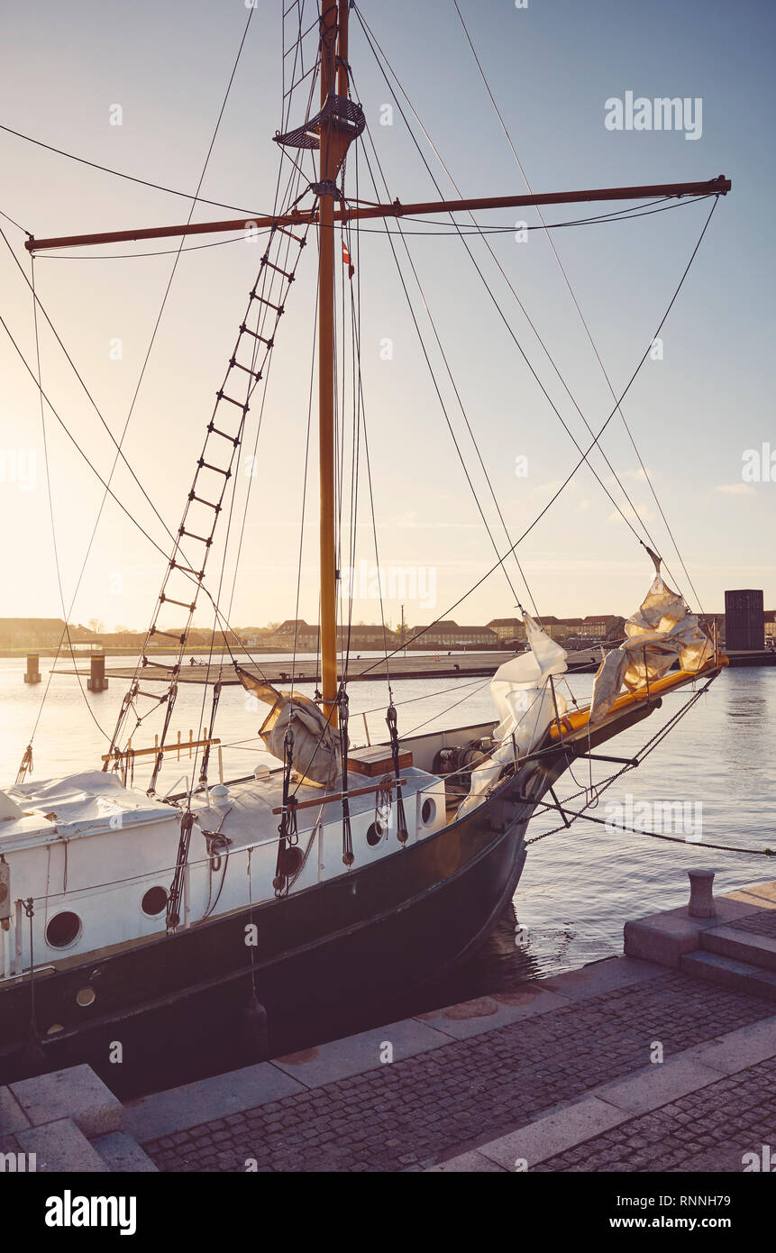 Vecchia goletta attraccata al molo in Copenhagen al tramonto, tonificazione del colore applicato, Danimarca. Foto Stock