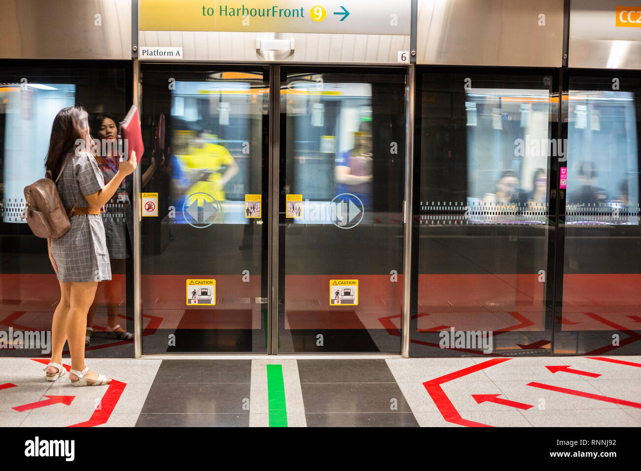 MRT Singapore Mass Rapid Transit. In attesa dei passeggeri a bordo del treno in arrivo. Foto Stock