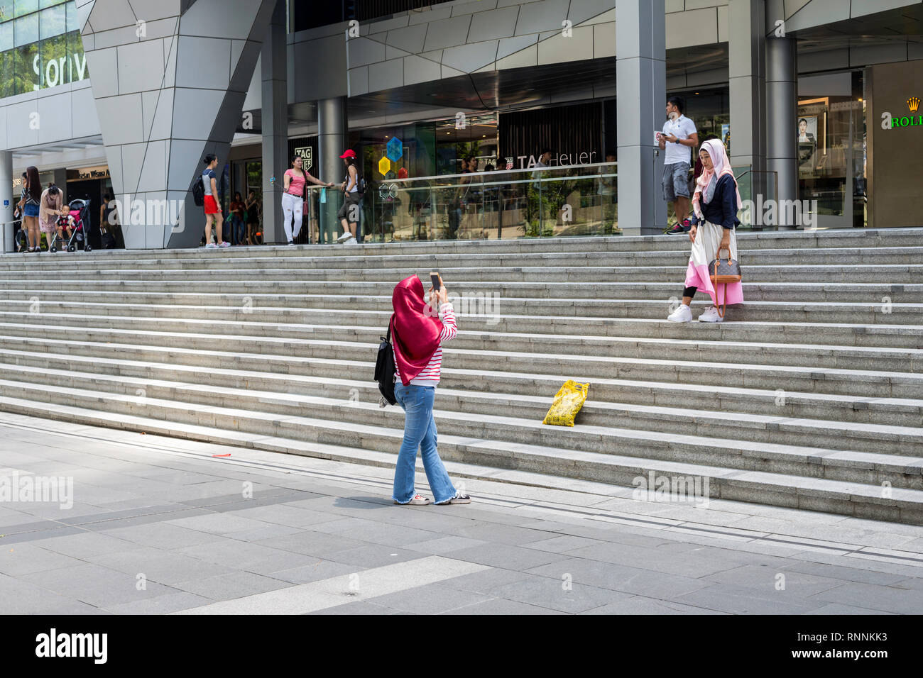 Di Singapore, Orchard Road Street scene, due acquirenti scattare una foto. Foto Stock