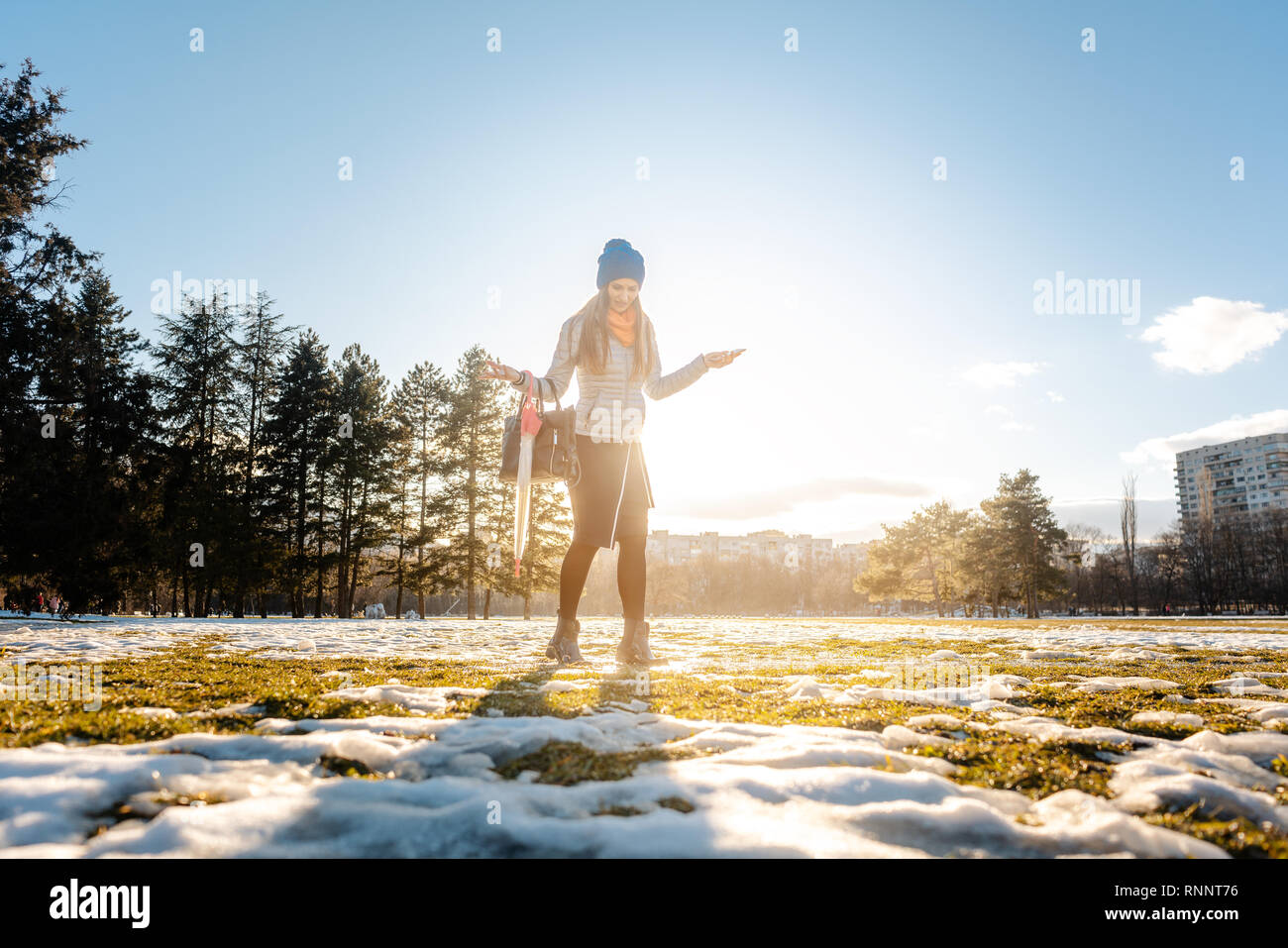 Donna che cammina attraverso il viscido neve Foto Stock