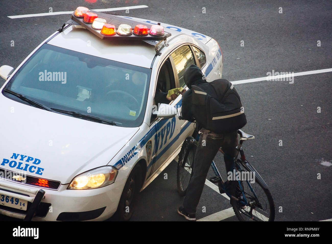 Ufficiali di NYPD emettere un biglietto per un ciclista per un non meglio specificato infrazione in bicicletta lane sulla Nona Avenue nel quartiere di Chelsea di New York sabato 9 febbraio, 2019. (© Richard B. Levine) Foto Stock