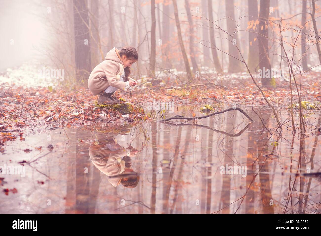 Ragazza 7 anni, nella foresta di nebbia all acqua lacche, riflessione, Baden Württemberg, Germania Foto Stock
