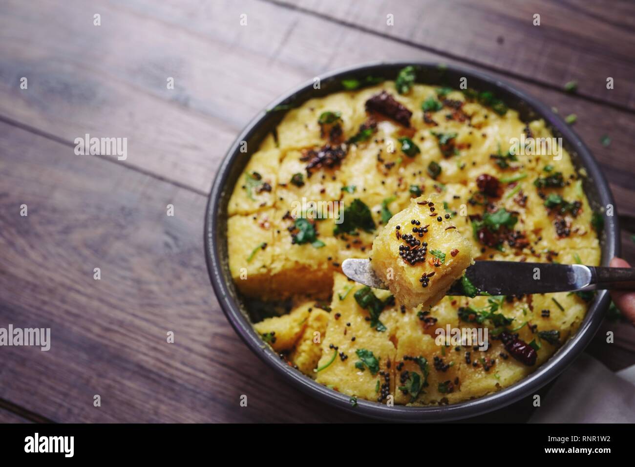 Dhokla fatti in casa - cotto a vapore di farina di ceci torta dal Gujarat, India il fuoco selettivo Foto Stock