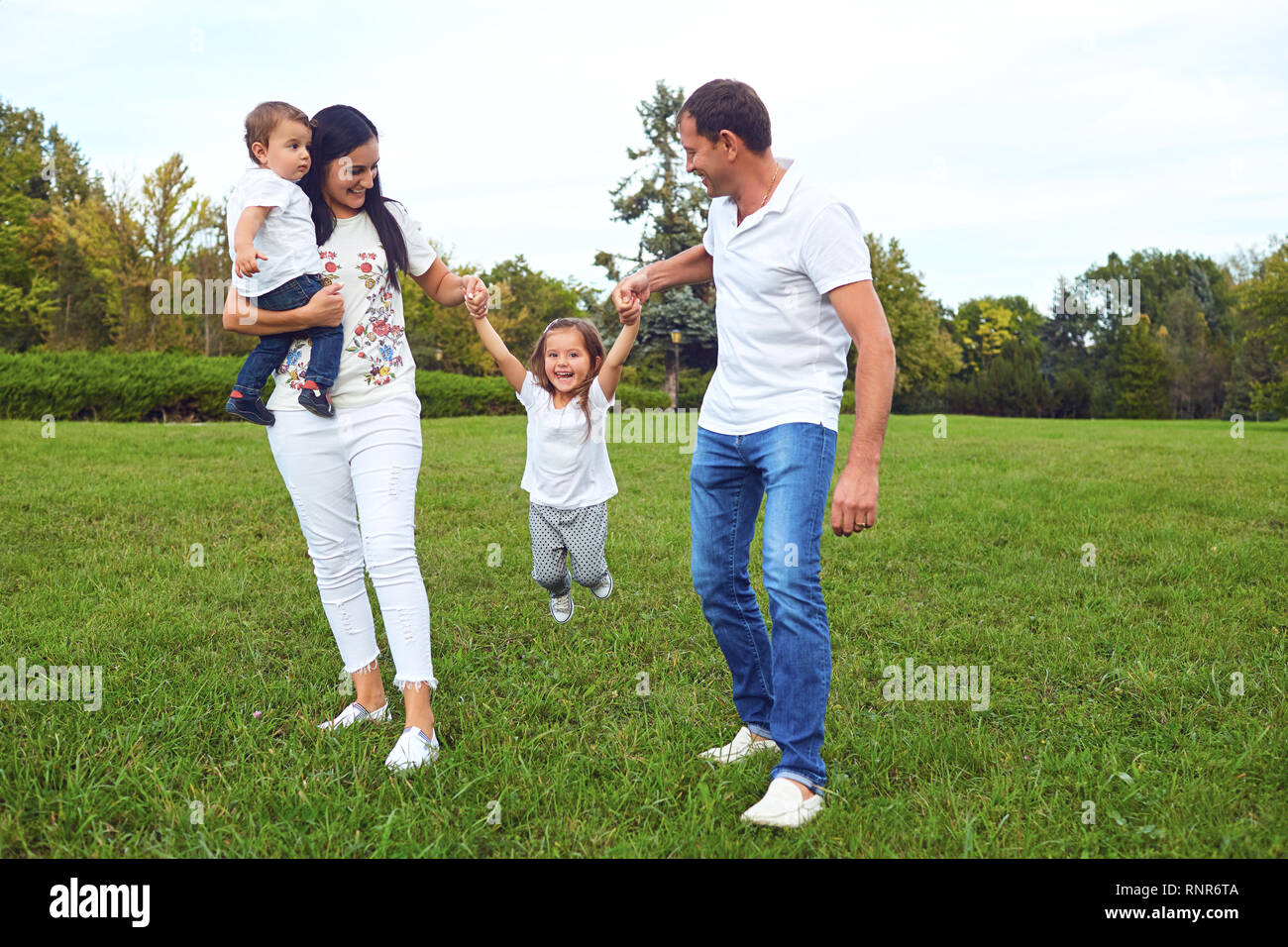 Famiglia con bambini che giocano sull'erba nel parco. Foto Stock