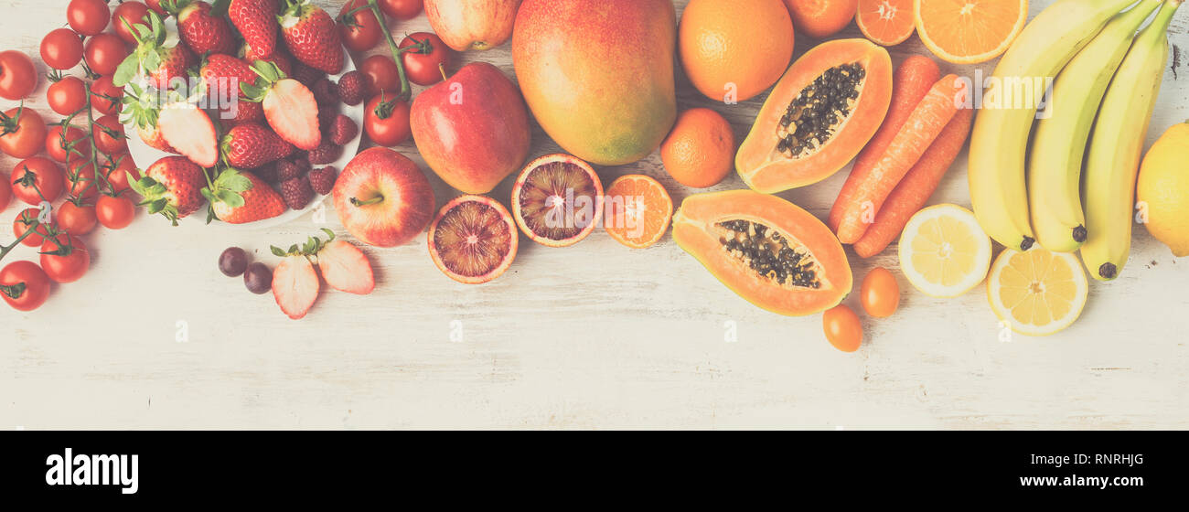 Lunga foto banner e colorati di frutta e verdura in rosso giallo arancio colori sul bianco tavola con copia spazio, tonica, vista dall'alto, il fuoco selettivo Foto Stock
