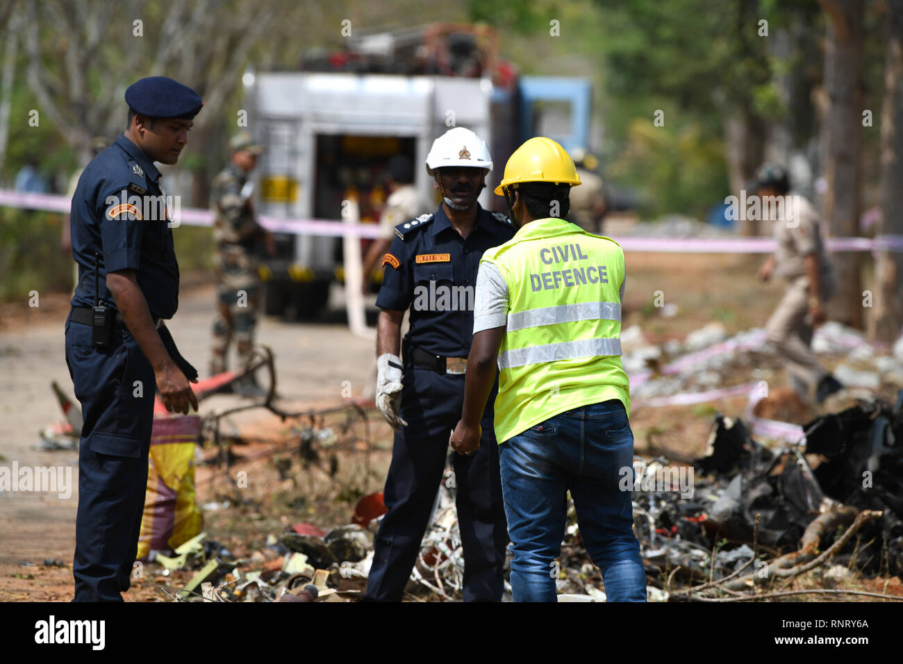 I funzionari sono visibile ispezionando i detriti di 1 dei 2 Surya Kiran che si è schiantato in Bengaluru prima che l'aria-show che inizia domani dove 2 piloti sono stati feriti e 1 morti accertati. Foto Stock