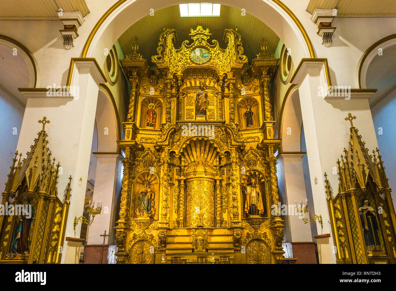 L'altare maggiore della chiesa di San Jose in stile barocco decorato con foglia oro e statue religiose, Panama City, Panama. Foto Stock