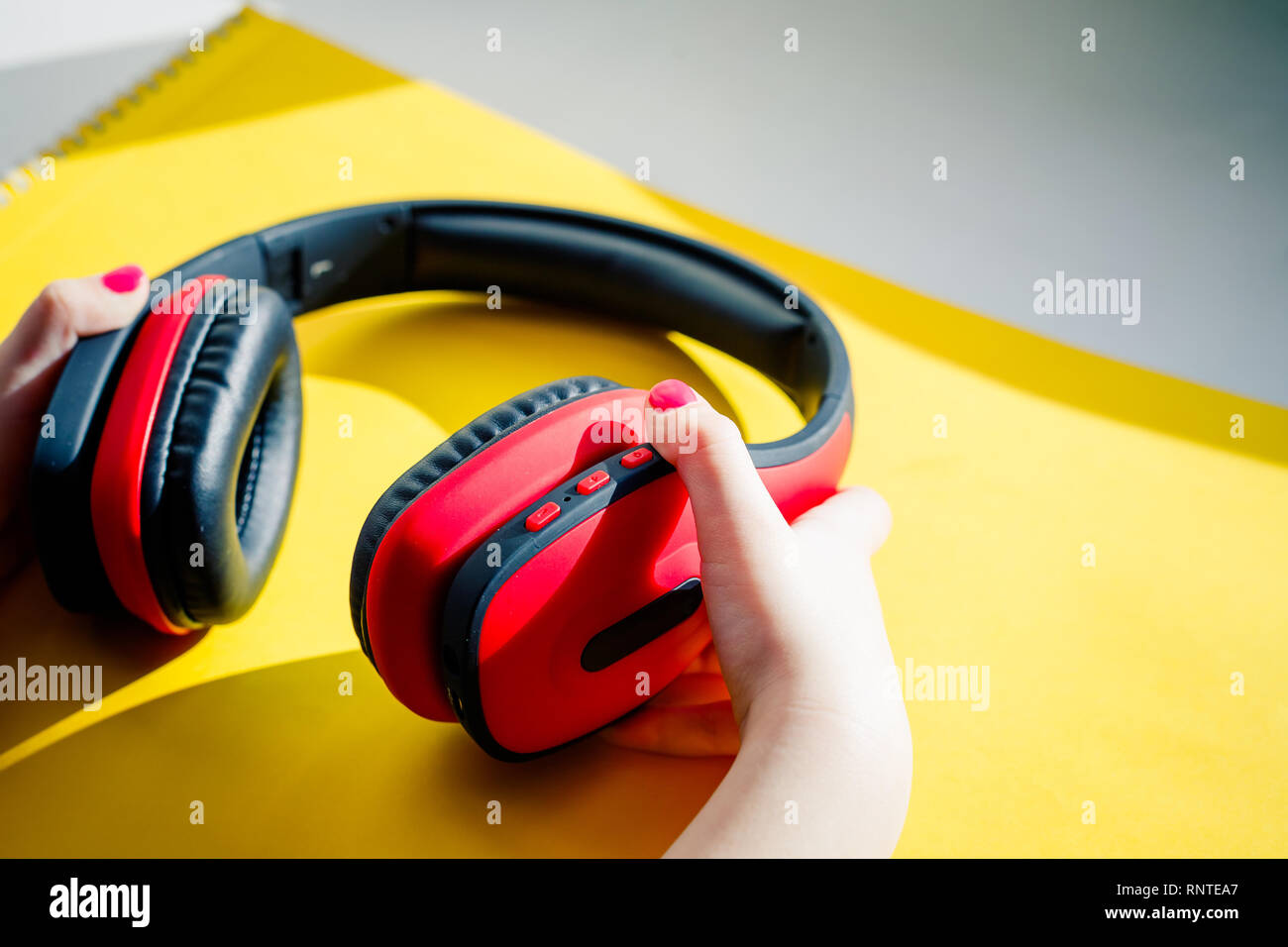 Cuffie wireless su vivido colore di sfondo. Appartamento in stile minimale. Design e colori.Elegante e moderna con le cuffie Cuffie su sfondo giallo in Foto Stock