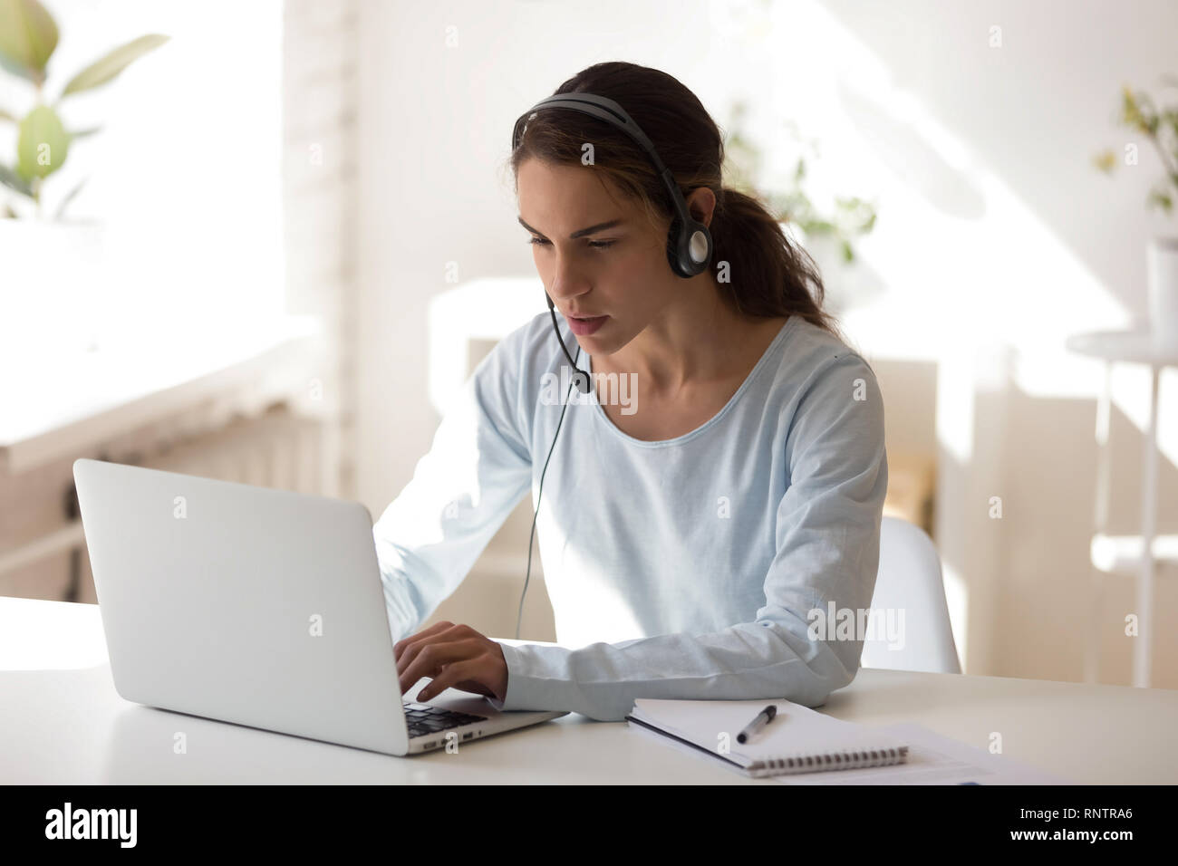 Giovani femmine studiare online utilizzando la cuffia e il computer Foto Stock