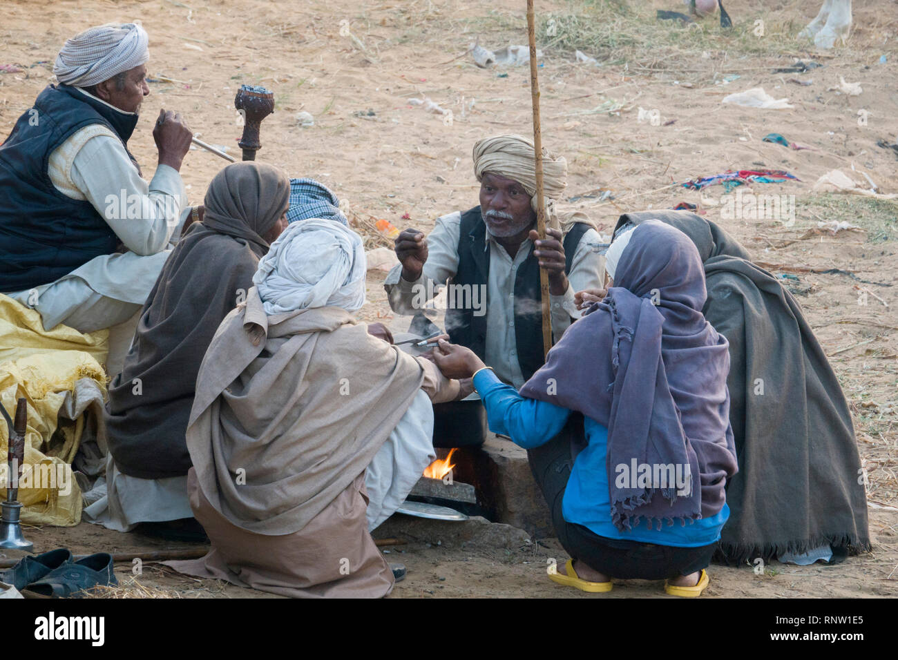 Marwari horse agricoltori sedersi attorno a un fuoco su una fredda mattina a Pushkar Camel Fair in Rajasthan, India Foto Stock