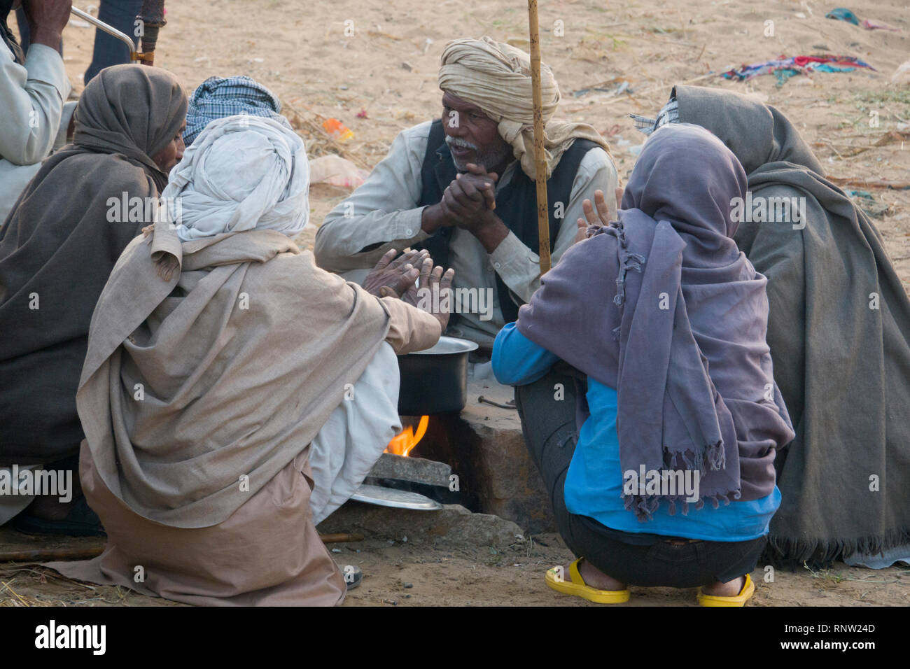 Marwari horse agricoltori sedersi attorno a un fuoco su una fredda mattina a Pushkar Camel Fair in Rajasthan, India Foto Stock