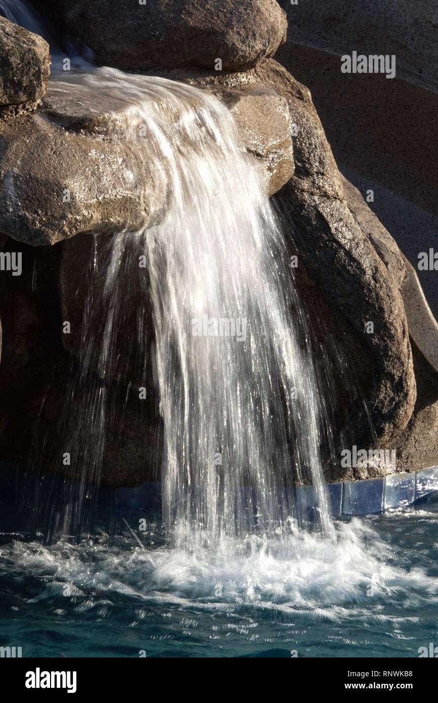 Una vista ravvicinata di un flusso di acqua in una sfocatura da una cascata da un lungo la velocità dello shutter di esposizione. Foto Stock