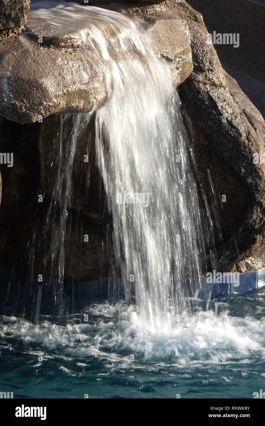 Una vista ravvicinata di un flusso di acqua in una sfocatura da una cascata da un lungo la velocità dello shutter di esposizione. Foto Stock