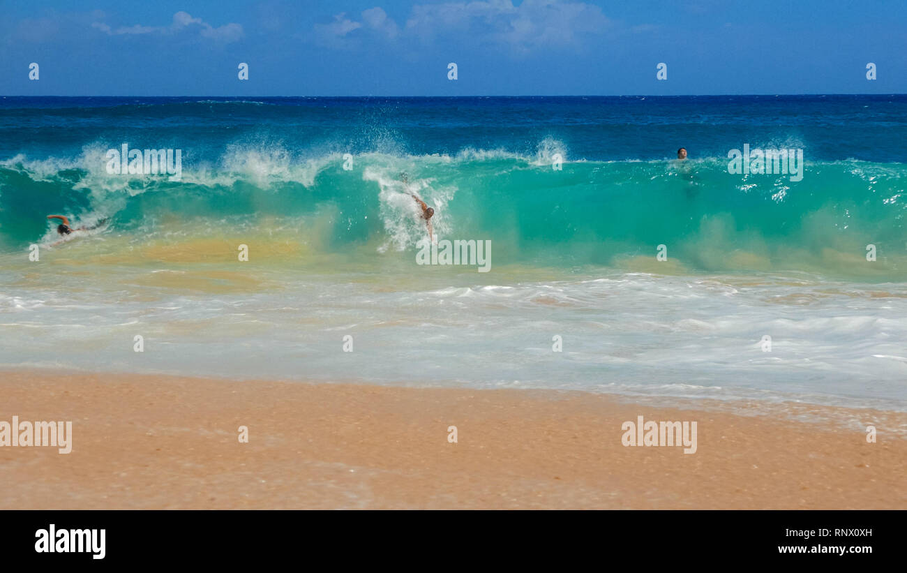WAIKIKI, STATI UNITI D'America - 6 agosto 2015: un colpo del corpo surfisti a spiaggia sabbiosa Foto Stock