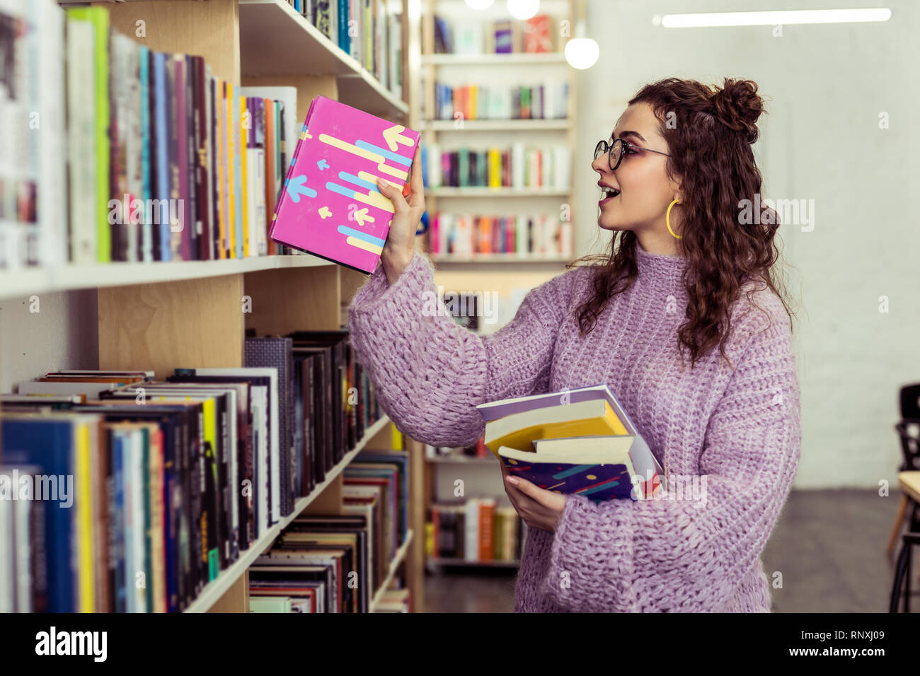 Allegro giovane ragazza mettere giù leggere il libro rosa Foto Stock