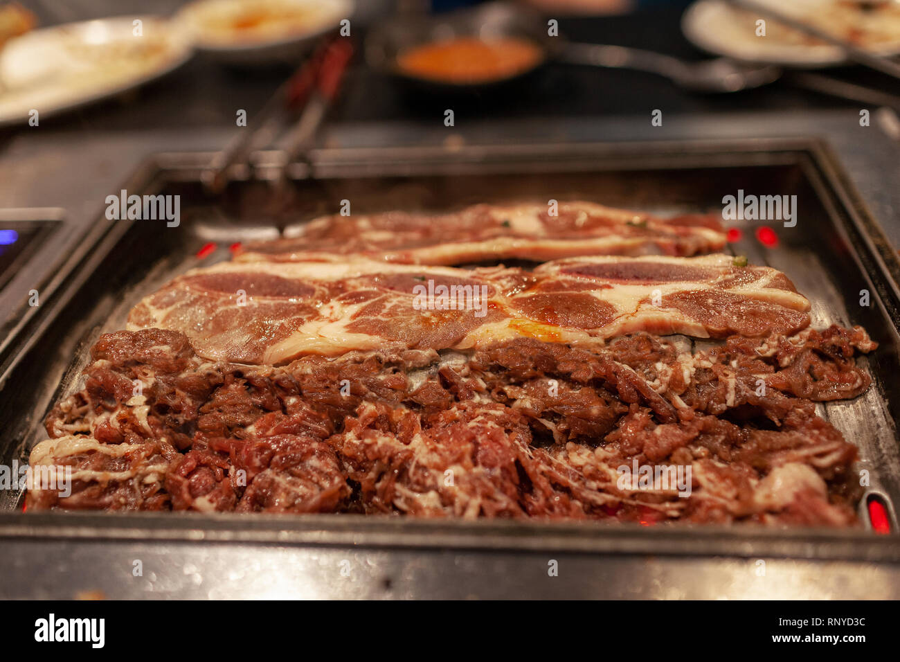 Korean barbecue in stile con succosa carne di manzo crudo e nervature brevi sulla stufa calda piastra grill. Foto Stock