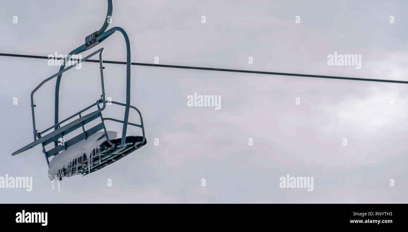 Impianti di risalita con neve e ghiaccioli contro il cielo luminoso Foto Stock