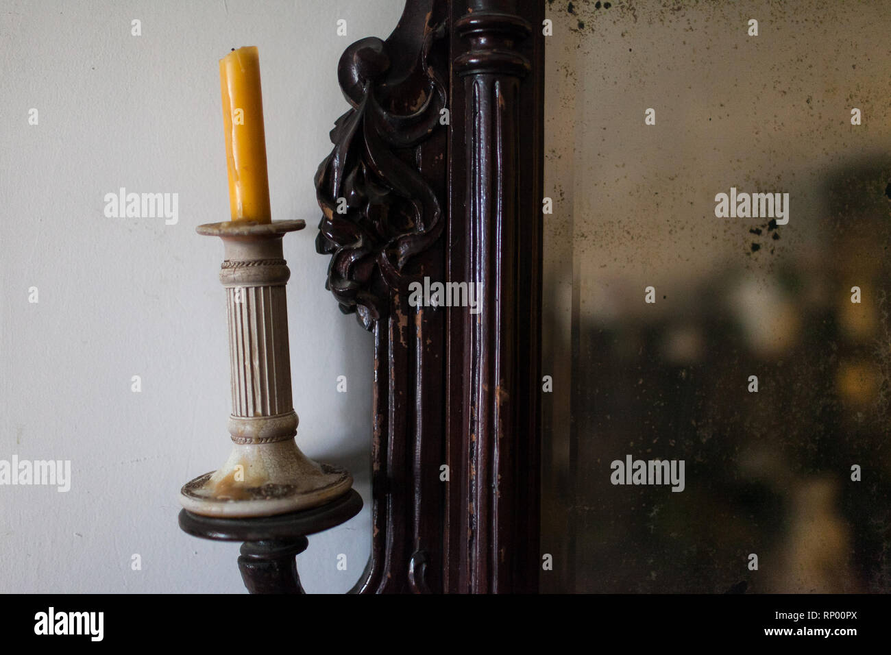 Antico candelabro con una candela e mirrir con sculture in legno Foto Stock