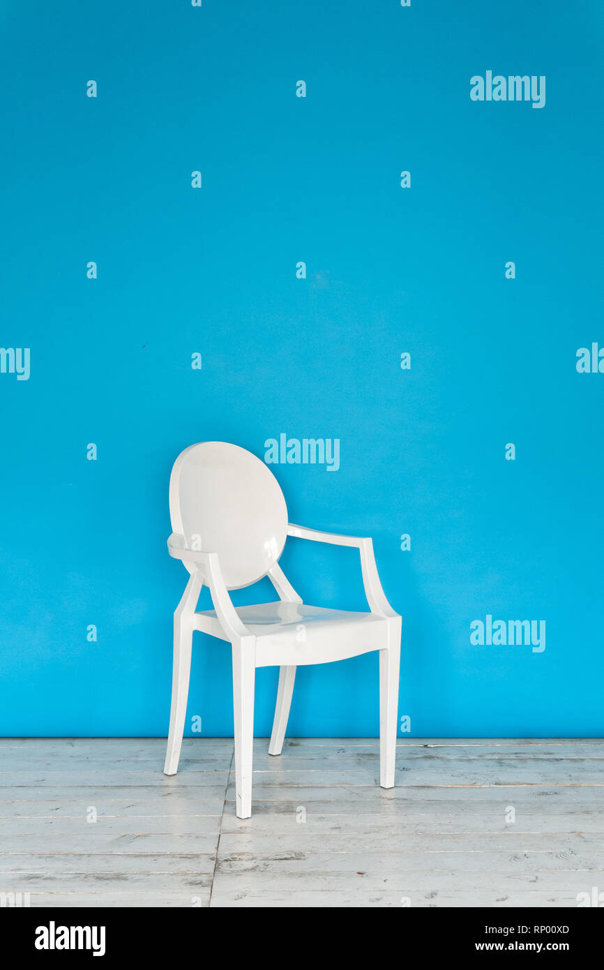 Lo spazio di lavoro della foto in studio con una carta blu di sfondo e sedia. Foto Stock