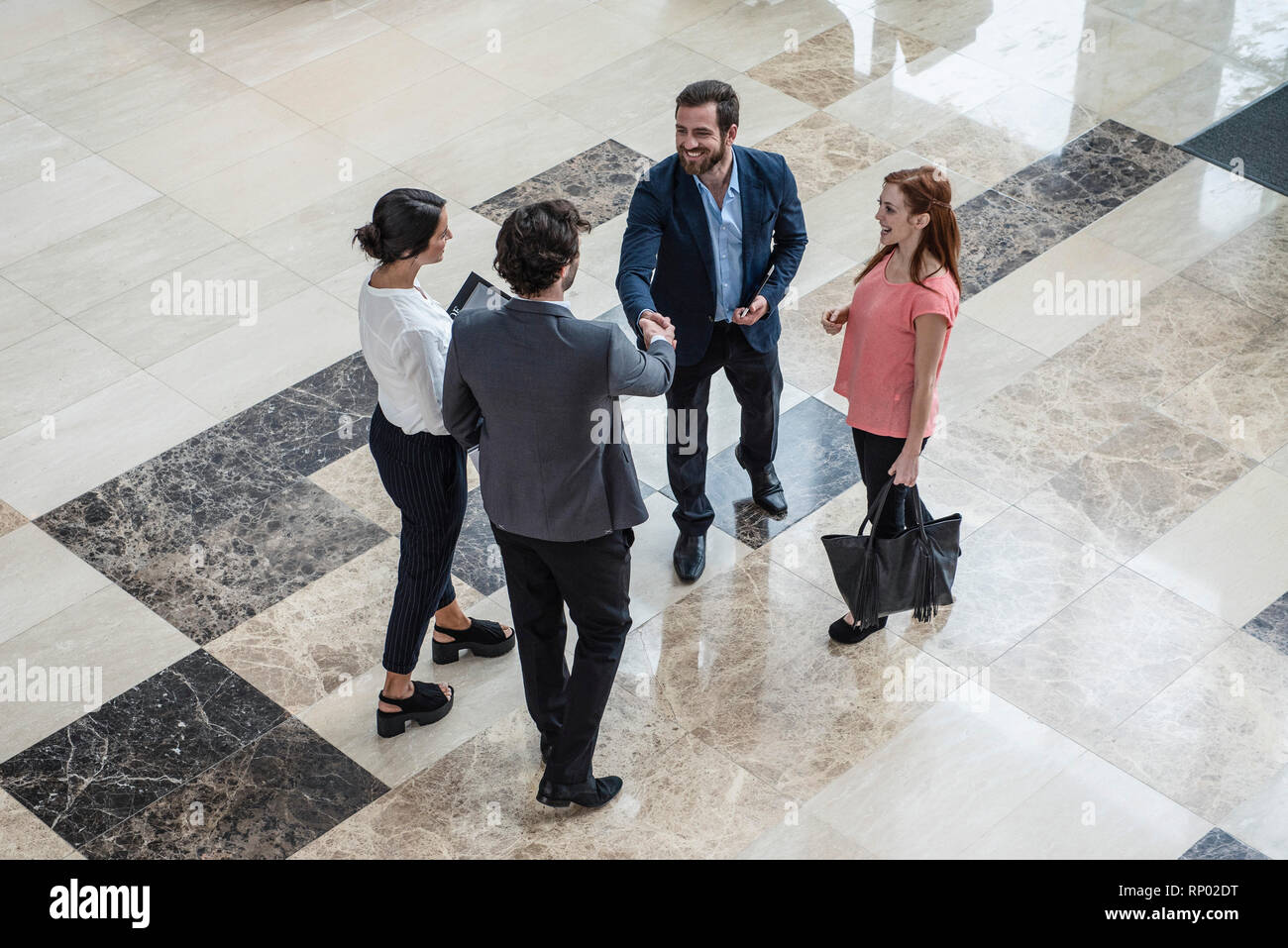 La gente di affari saluto ogni altro nella hall hotel Foto Stock