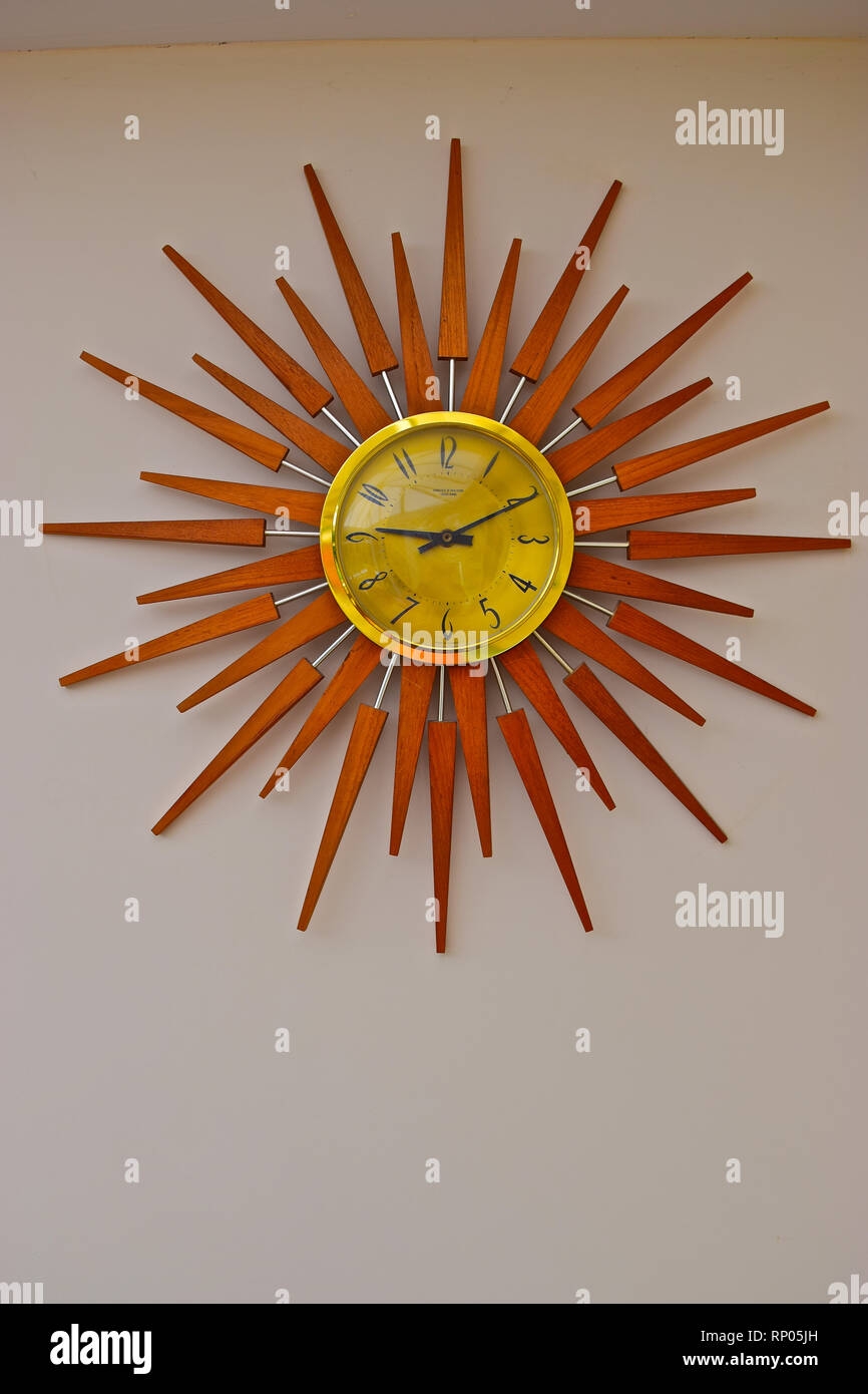 Uno stile retrò orologio da parete in legno a forma di sole circondano  risalente agli anni settanta Foto stock - Alamy