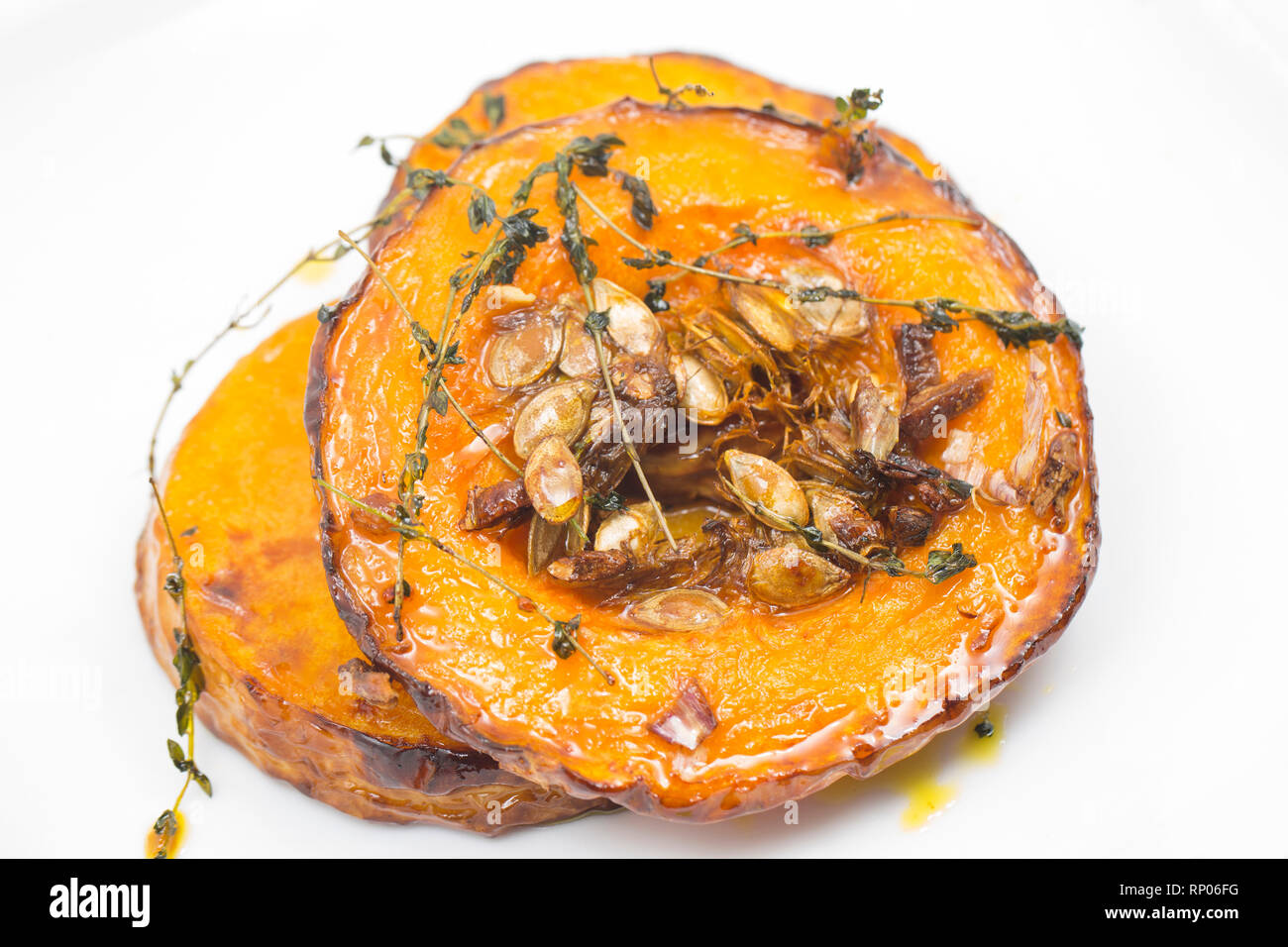 Turni di zucca con la pelle sulla sinistra e i semi di sinistra in acquistato da un supermercato che sono state tostate in forno con olio d'oliva, schiacciare Foto Stock