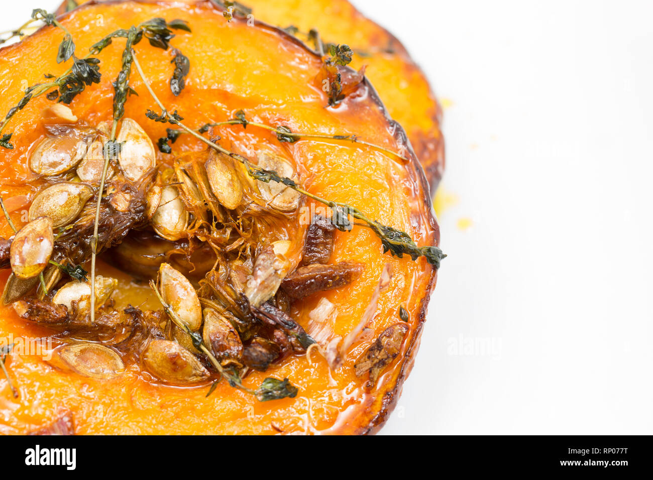 Turni di zucca con la pelle sulla sinistra e i semi di sinistra in acquistato da un supermercato che sono state tostate in forno con olio d'oliva, schiacciare Foto Stock