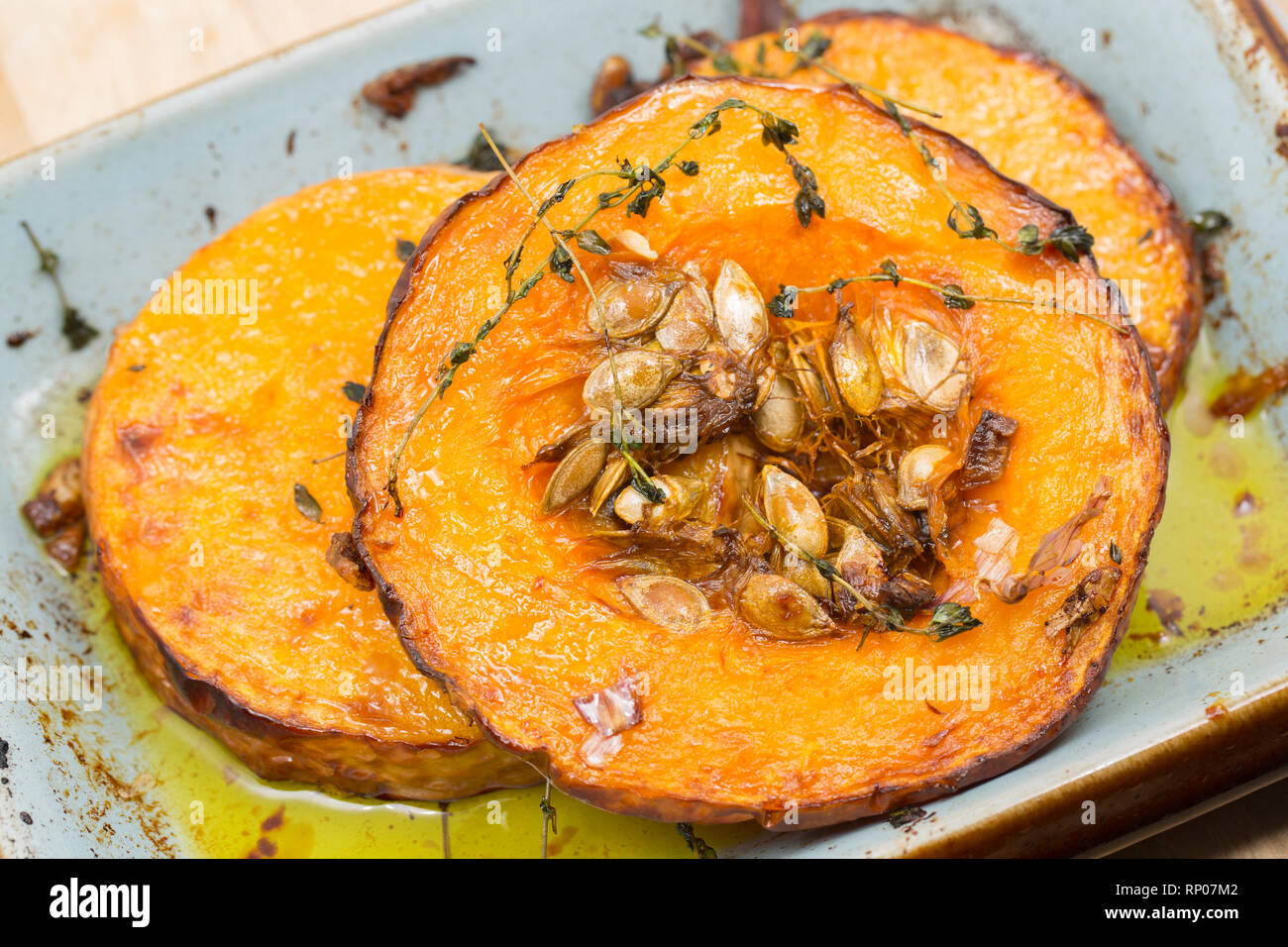 Turni di zucca con la pelle a sinistra su acquistato da un supermercato che sono state tostate in forno con olio d'oliva, aglio schiacciato e fresco Foto Stock