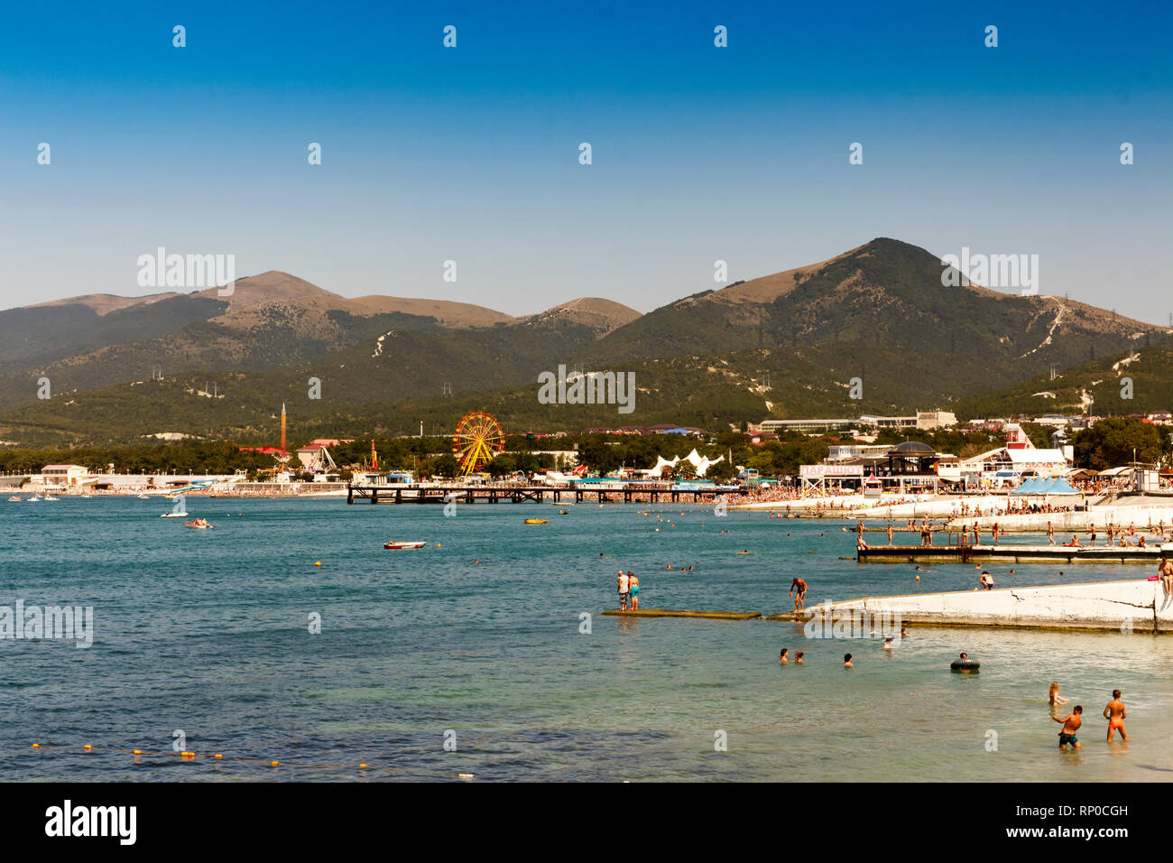 Resort di russo. La Russia Regione Krasnodar, la spiaggia del villaggio Kabardinka 26.08.2017 11: 50 am vacanzieri sulla spiaggia immersione dalla frangiflutti. Foto Stock