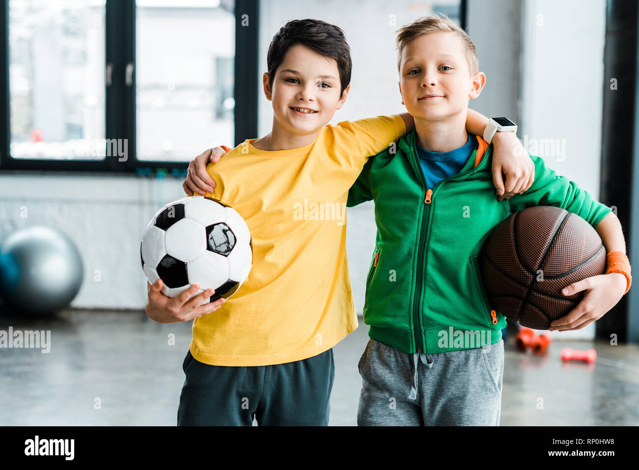 Piacere ragazzi abbracciando mentre posa con sfere Foto Stock